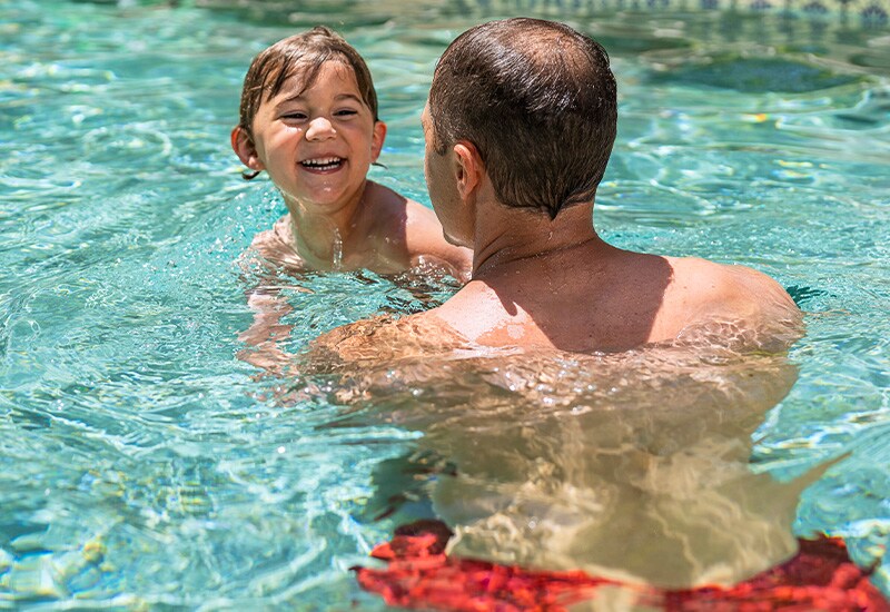 baby swimming with dad